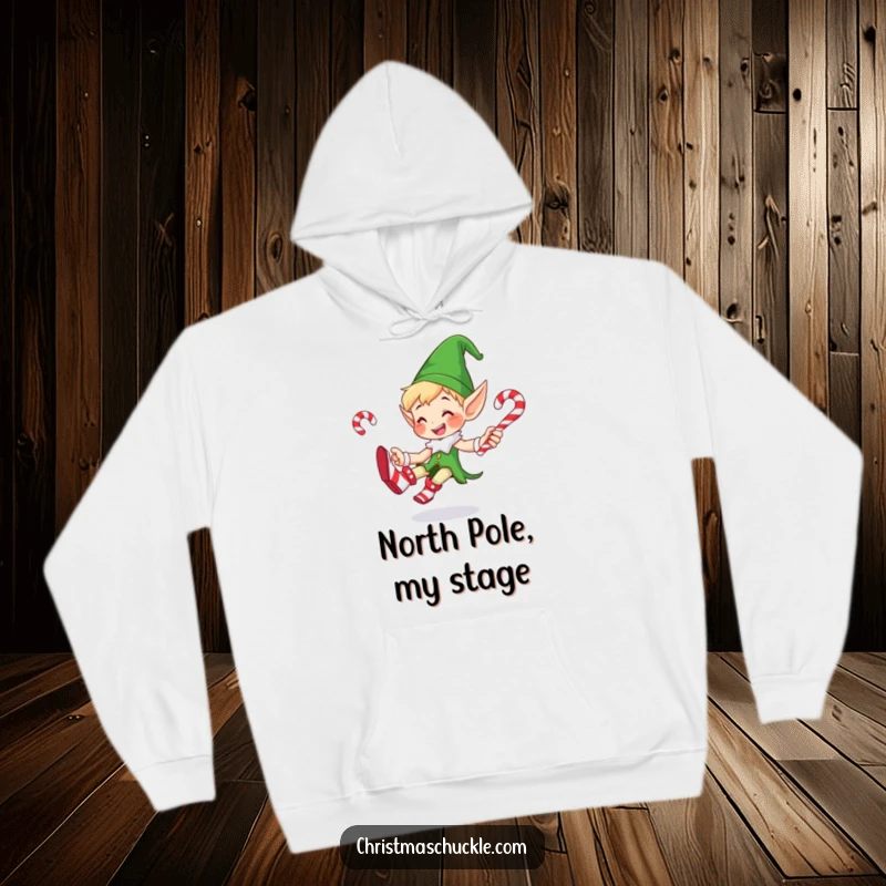 Funny hoodie depicting a cheerful elf in big clown shoes, juggling multiple candy canes with a joyful and slightly chaotic energy, ideal for winter.